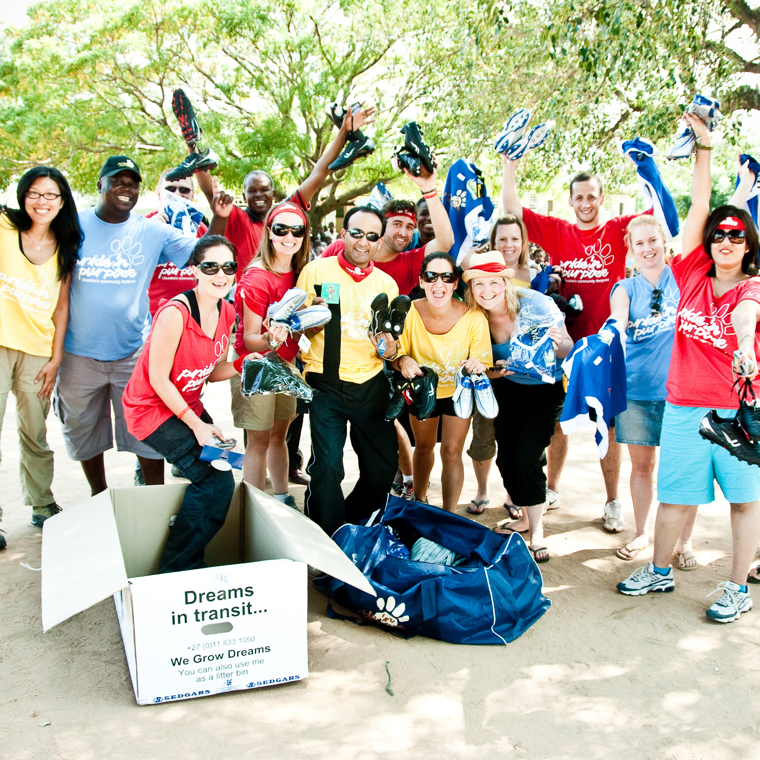 A group of Virgin employees smile and hold their hands up in celebration