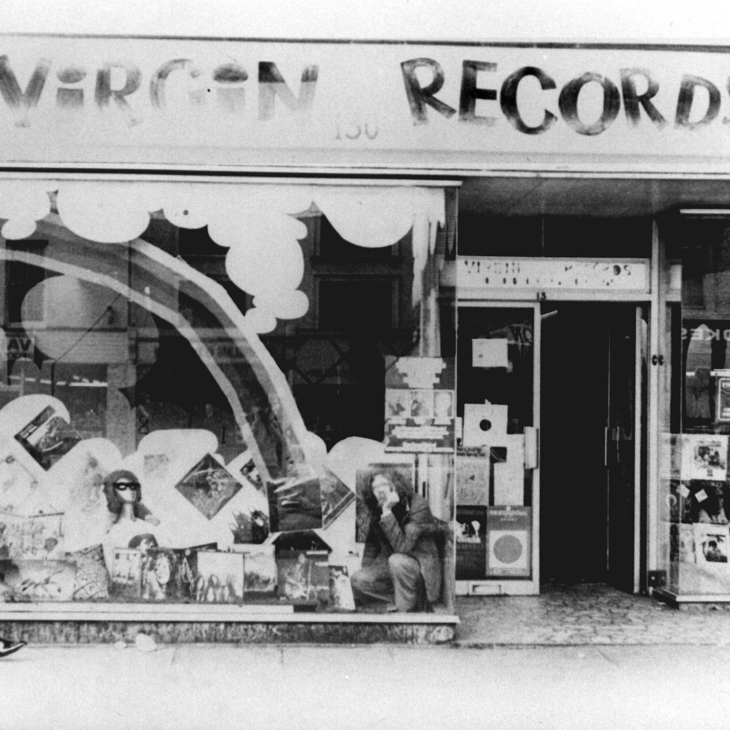 Richard Branson in the 1970s sitting in the shop window of Virgin Records