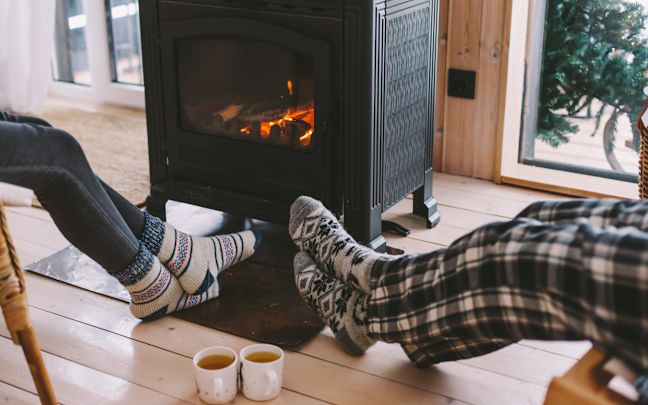 An image of people relaxing by the fire in pyjamas